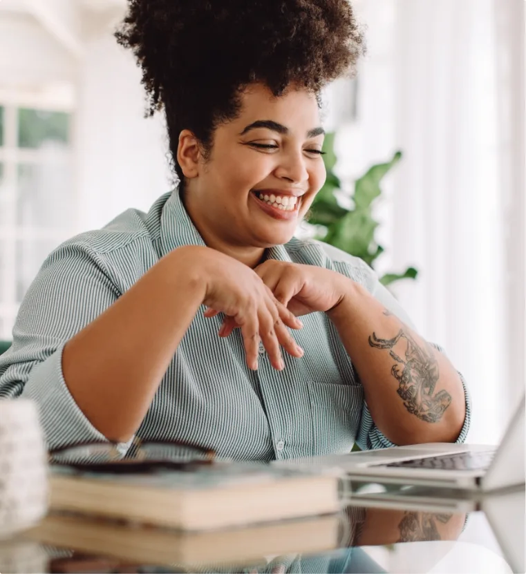 A happy woman in front of a laptop